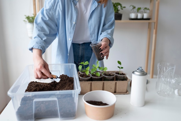 Donna che ha un giardino sostenibile in casa