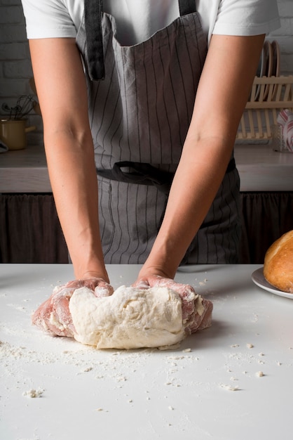 Donna che impasta la pasta sul contatore