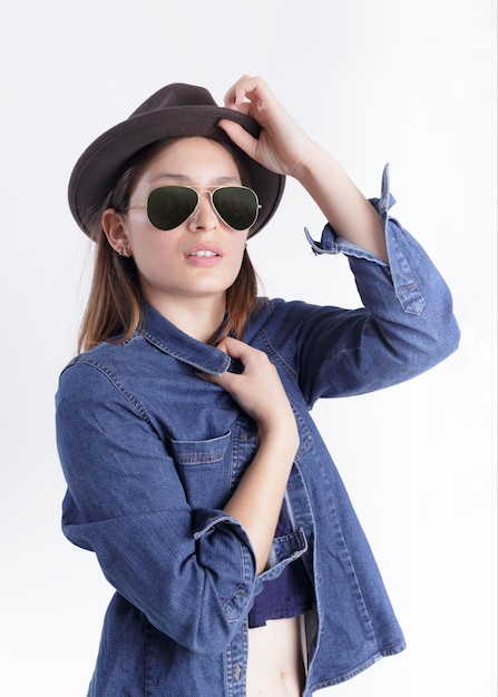 Donna che indossa cappello e occhiali con camicia blu