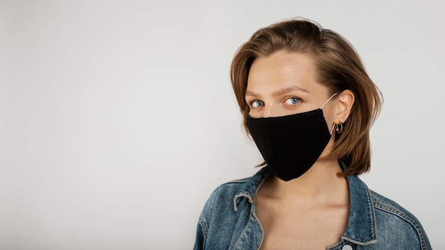 Donna che indossa giacca di jeans e maschera