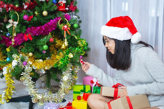 donna che indossa il cappello di Natale felice con un regalo di Natale