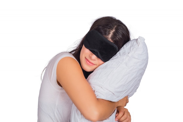 Donna che indossa la maschera del sonno e che tiene un cuscino.