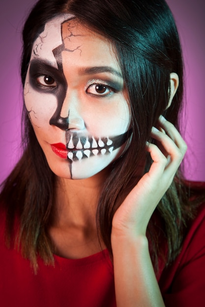 Donna che indossa la maschera di Halloween e toccando i capelli