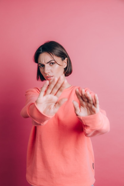 Donna che indossa un maglione casual su sfondo espressione disgustata, scontenta e timorosa che fa la faccia di disgusto perché reazione di avversione