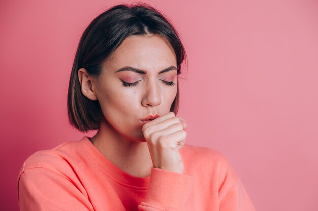 Donna che indossa un maglione casual su sfondo sensazione di malessere e tosse come sintomo di raffreddore o bronchite. Concetto di assistenza sanitaria.