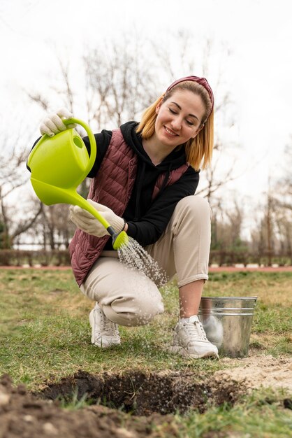 Donna che innaffia una pianta che ha piantato