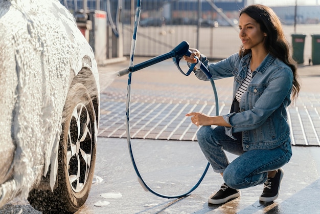 Donna che lava la sua auto all'aperto