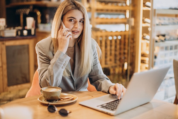 Donna che lavora al computer in un bar