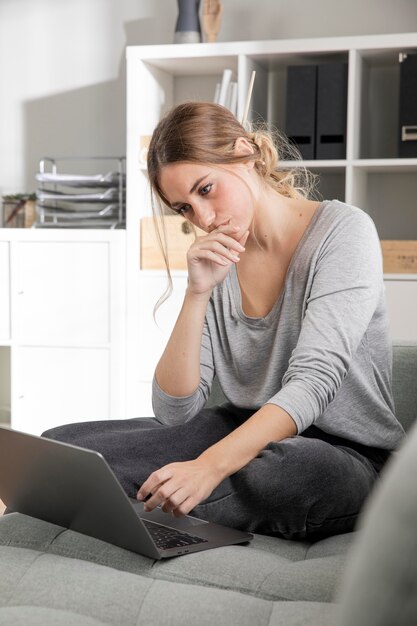 Donna che lavora al computer portatile al chiuso