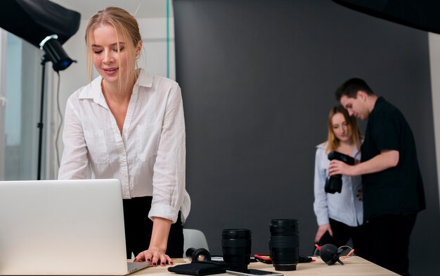 Donna che lavora al computer portatile e persone che guardano le foto