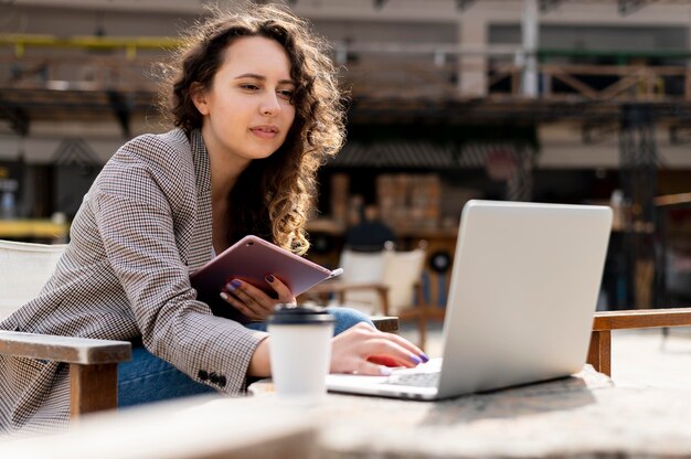 Donna che lavora con il colpo medio del computer portatile