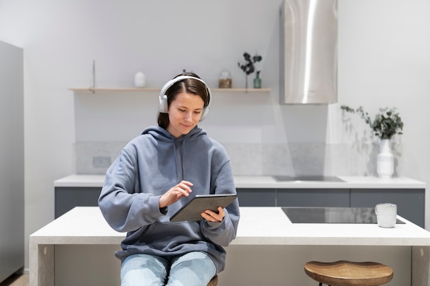 Donna che lavora dalla cucina di casa con tablet