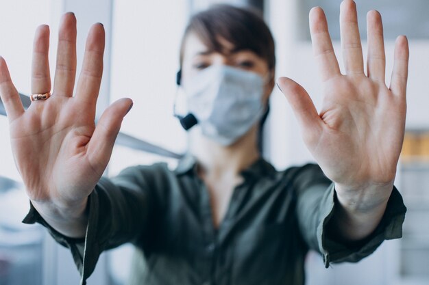 Donna che lavora in studio di registrazione e indossa la maschera