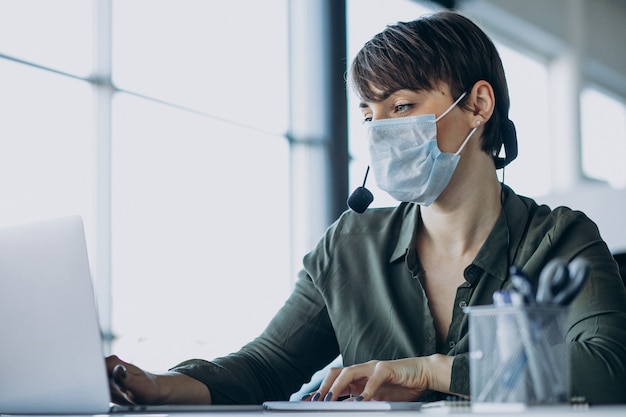 Donna che lavora in studio di registrazione e indossa la maschera