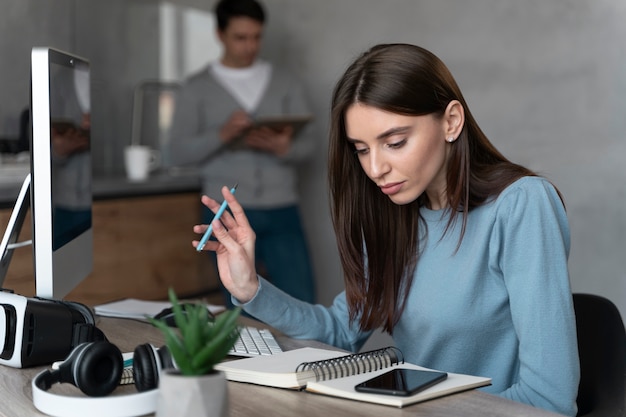 Donna che lavora nel campo dei media con personal computer e smartphone