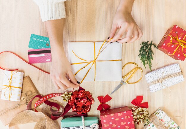 Donna che lega arco sul contenitore di regalo