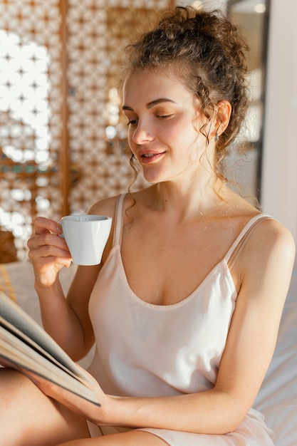 Donna che legge e che beve caffè