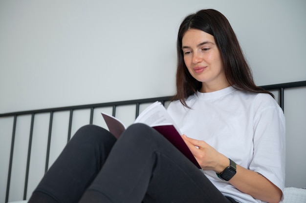 Donna che legge un libro a casa durante la quarantena