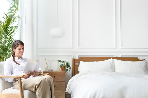 Donna che legge un libro nella sua camera da letto