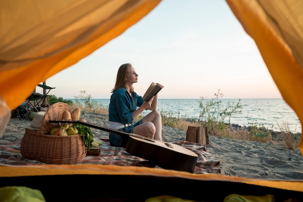 Donna che legge un libro sulla coperta da picnic