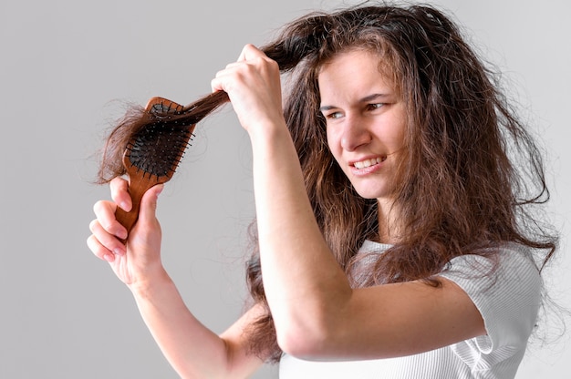 Donna che lotta per spazzolare i capelli