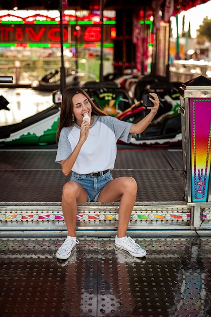 Donna che mangia il gelato che prende selfie