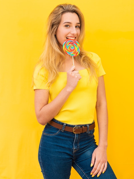 Donna che mangia lecca-lecca colorata