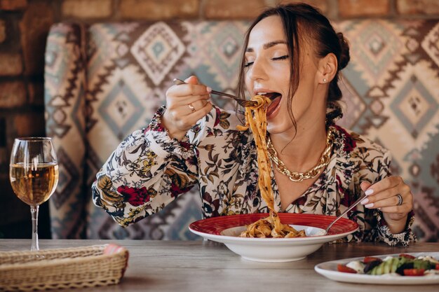 Donna che mangia pasta in un ristorante italiano