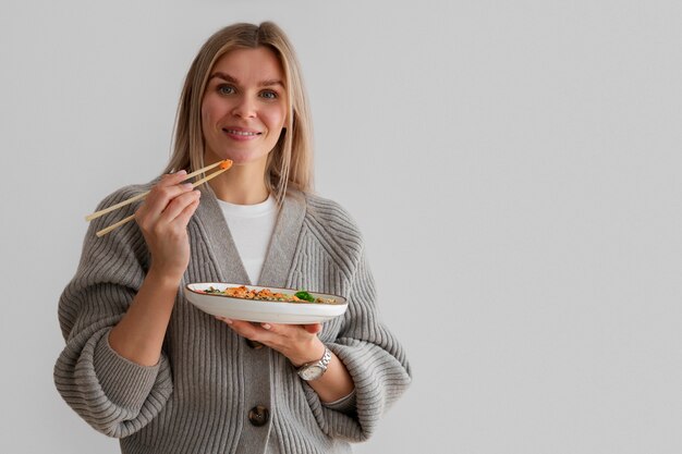 Donna che mangia piatto di frutti di mare con salmone