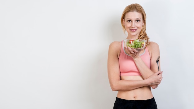 Donna che mangia un&#39;insalata di lattuga