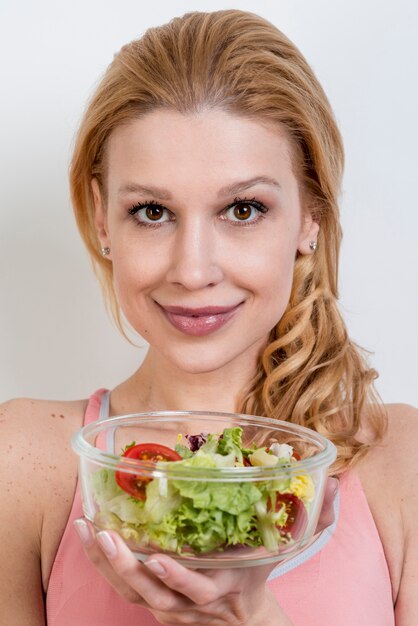 Donna che mangia un&#39;insalata di lattuga