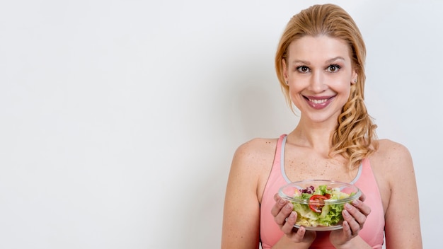 Donna che mangia un&#39;insalata di lattuga