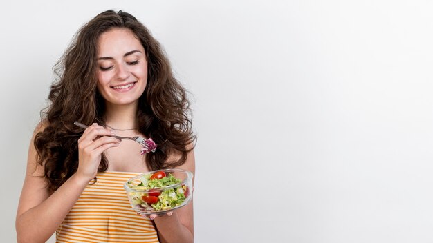 Donna che mangia un&#39;insalata di lattuga