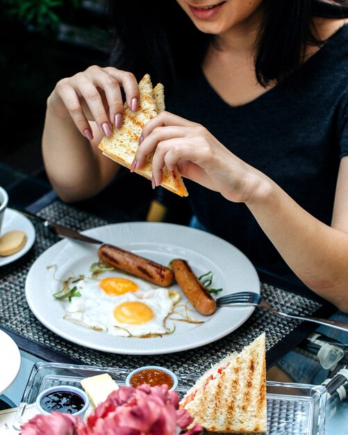 Donna che mangia un panino al tavolo