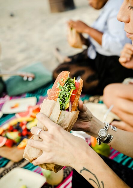 Donna che mangia un panino in spiaggia