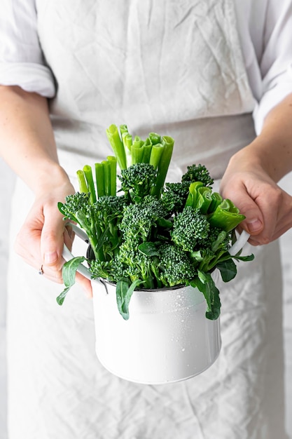 Donna che mantiene i broccoli organici freschi