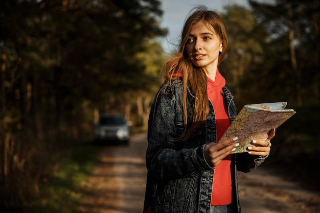 Donna che mantiene la mappa durante un viaggio su strada