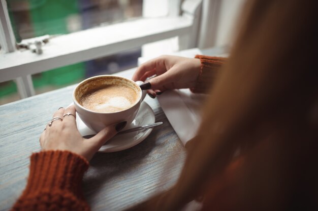 Donna che mantiene la tazza di caffè