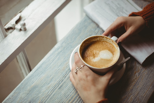 Donna che mantiene la tazza di caffè