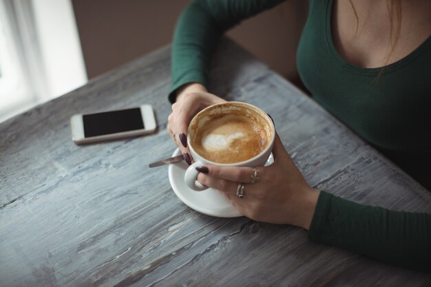 Donna che mantiene la tazza di caffè