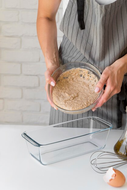 Donna che mette pasta nello stampo per dolci