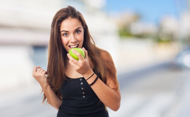 Donna che morde una mela verde