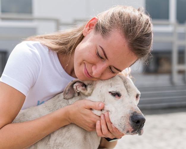 Donna che mostra affetto al simpatico cane da salvataggio al rifugio