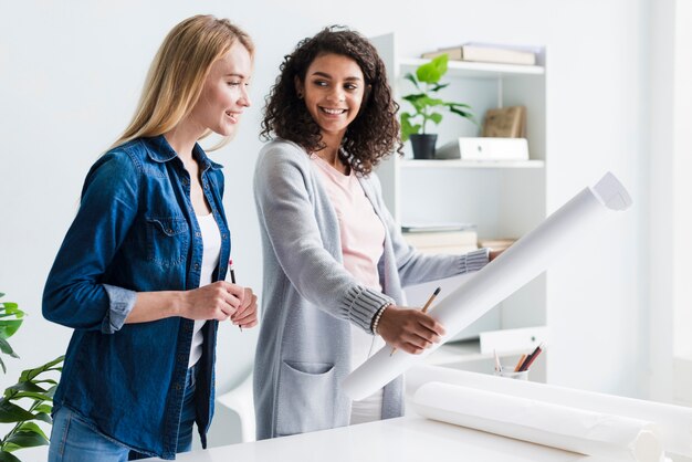 Donna che mostra foglio di carta femminile bionda collega