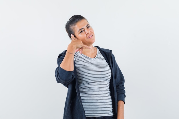 Donna che mostra il gesto del telefono in maglietta