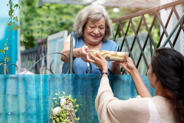 Donna che offre cibo al vicino