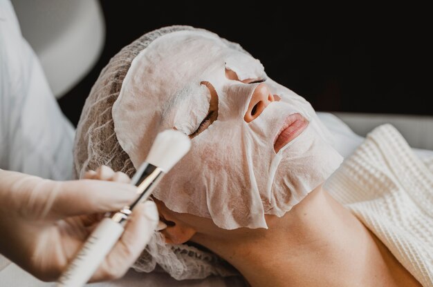 Donna che ottiene un trattamento con maschera per la pelle presso il centro benessere