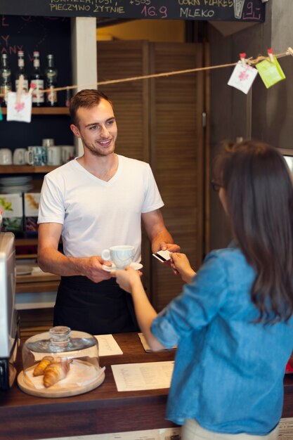 Donna che paga un caffè con carta di credito