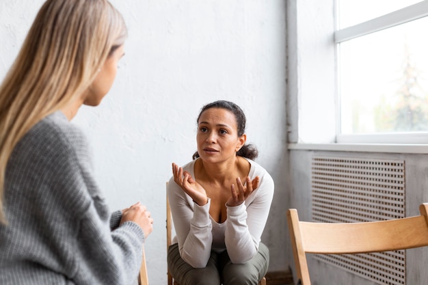 Donna che parla dei suoi problemi in una sessione di terapia di gruppo