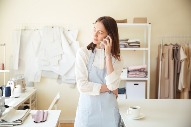 Donna che parla sul telefono in officina